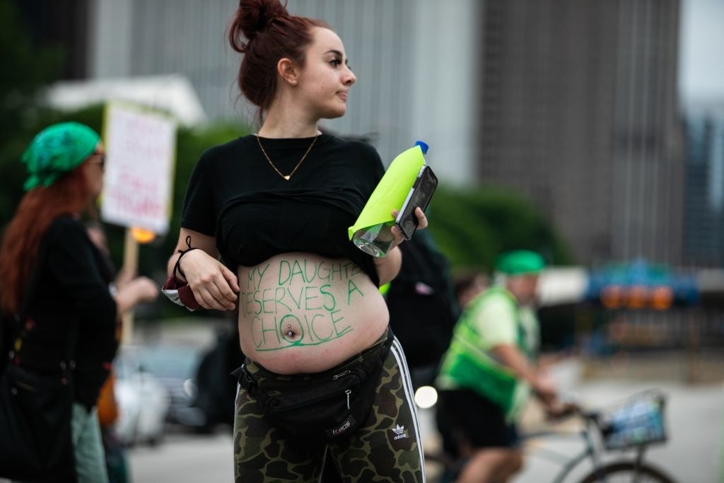 pregnant woman with my daughter deserves a choice written on her stomach
