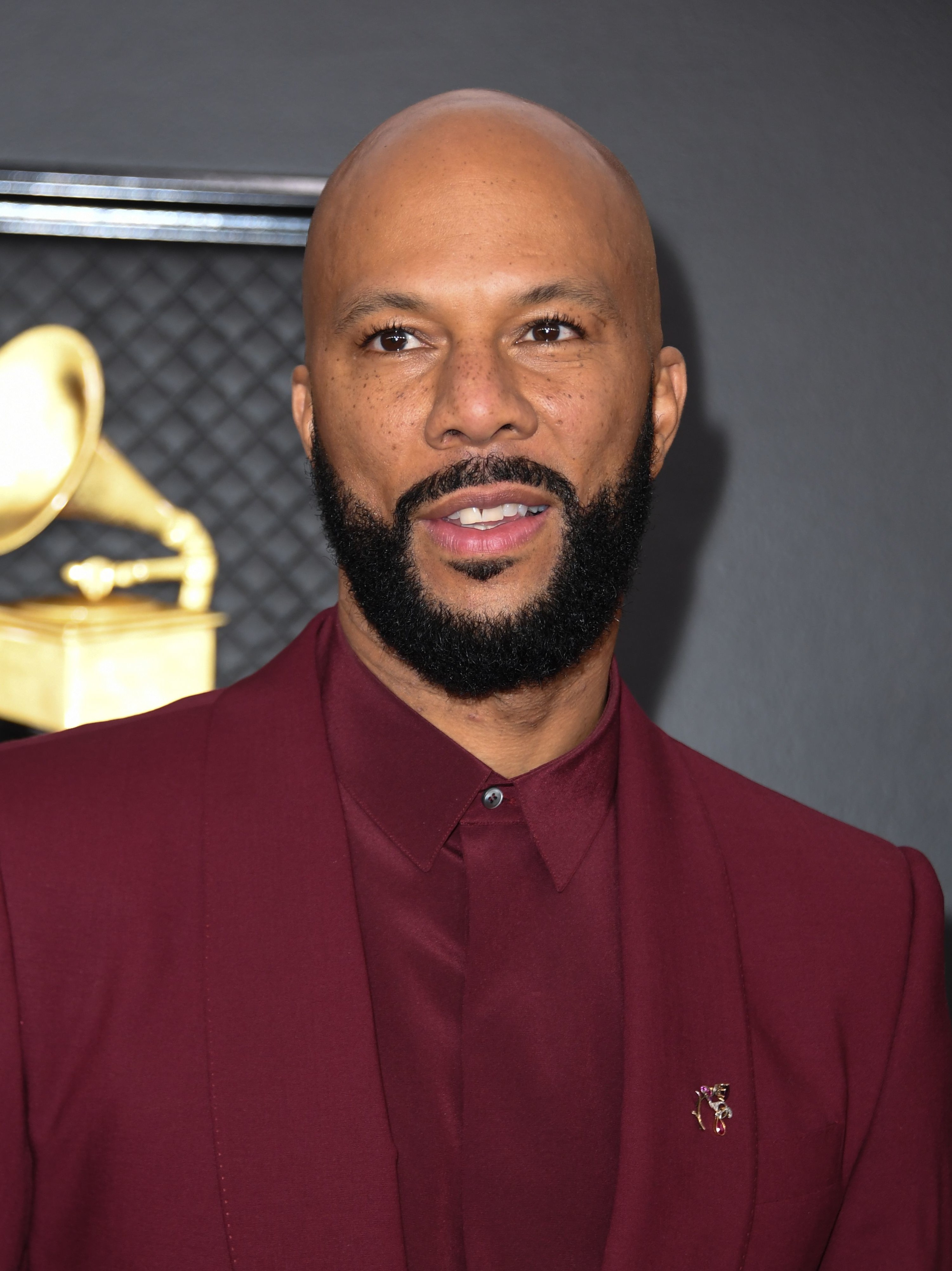 Close-up of Common with a beard and mustache and wearing a matching shirt and jacket