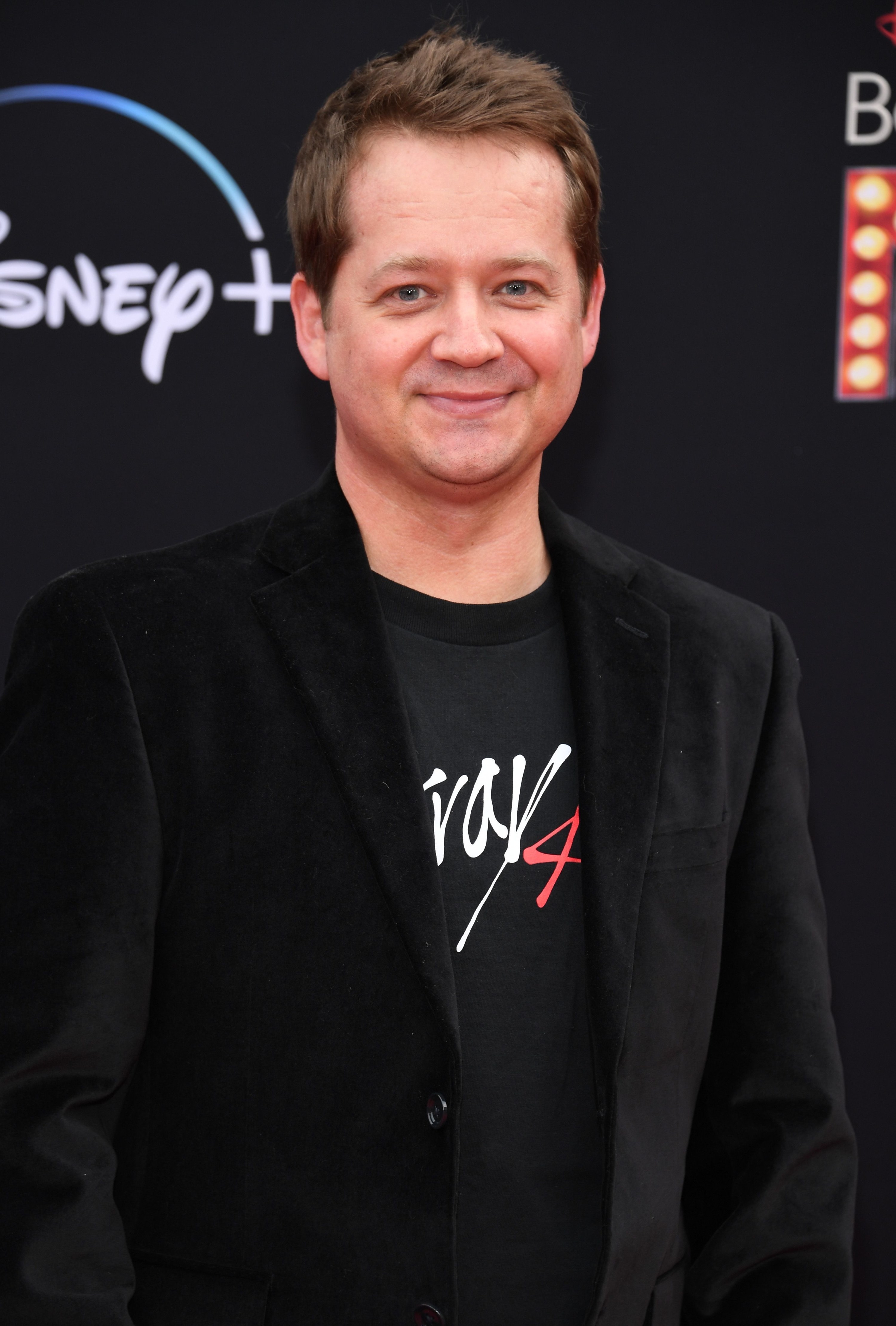 A smiling, clean-shaven Jason in a jacket and T-shirt