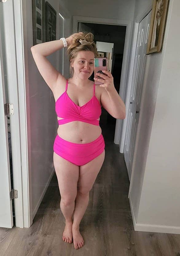 A reviewer wearing a hot pink wrap, push-up bikini