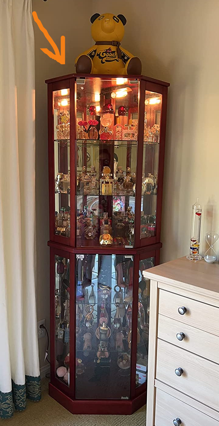 Reviewer image of cherry wooden mirrored corner cabinet next to dresser