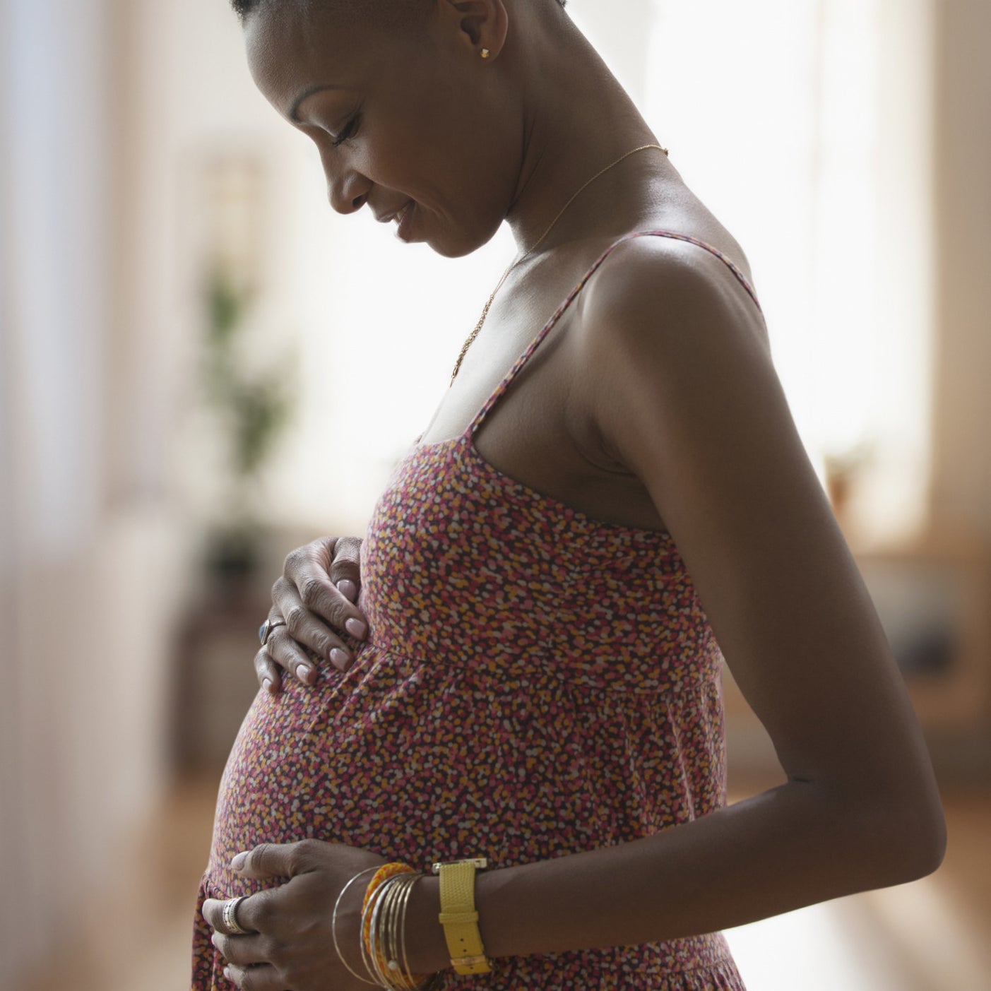 A woman holding her pregnant belly.