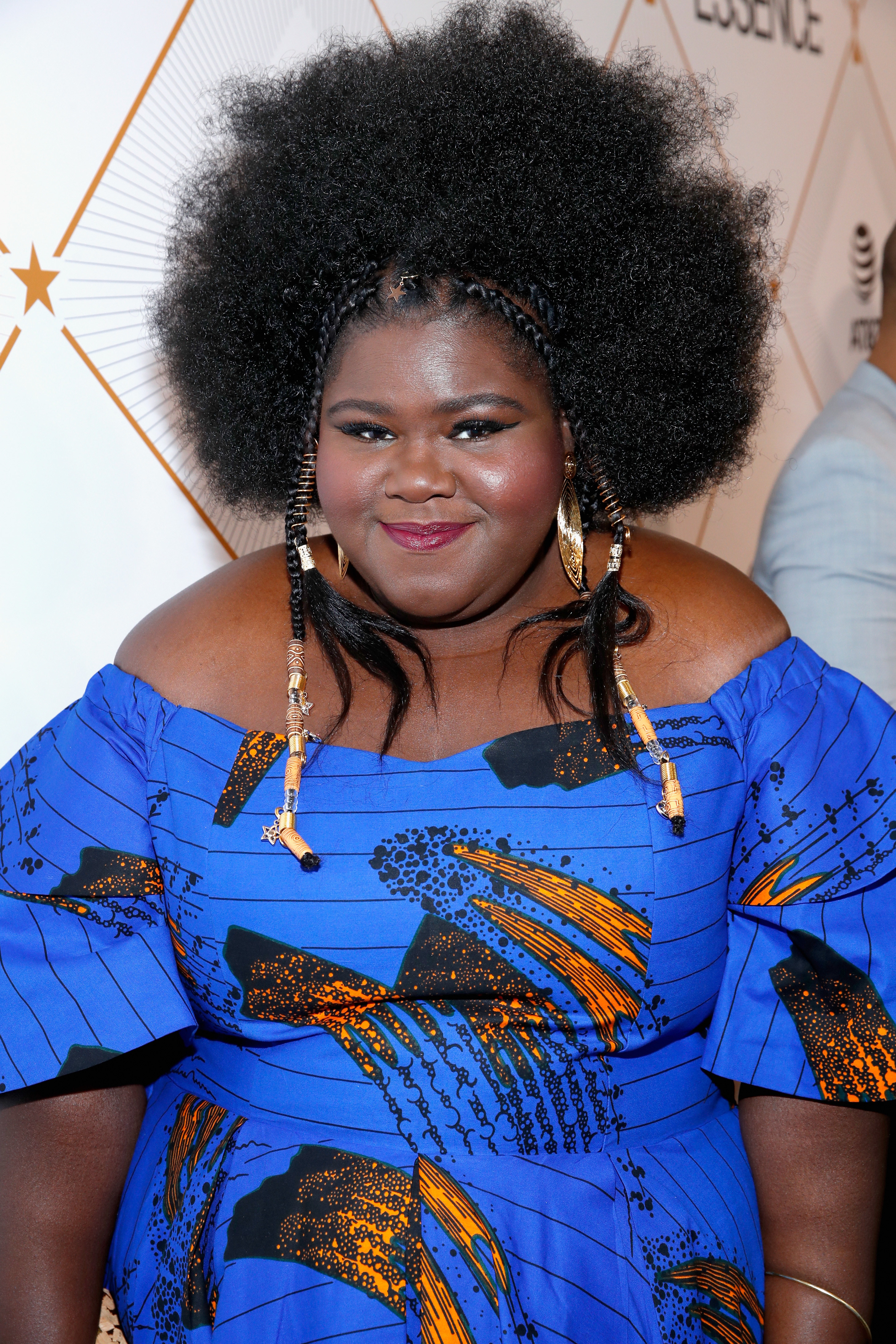 Gabourey in an off-the-shoulder print outfit and loose Afro