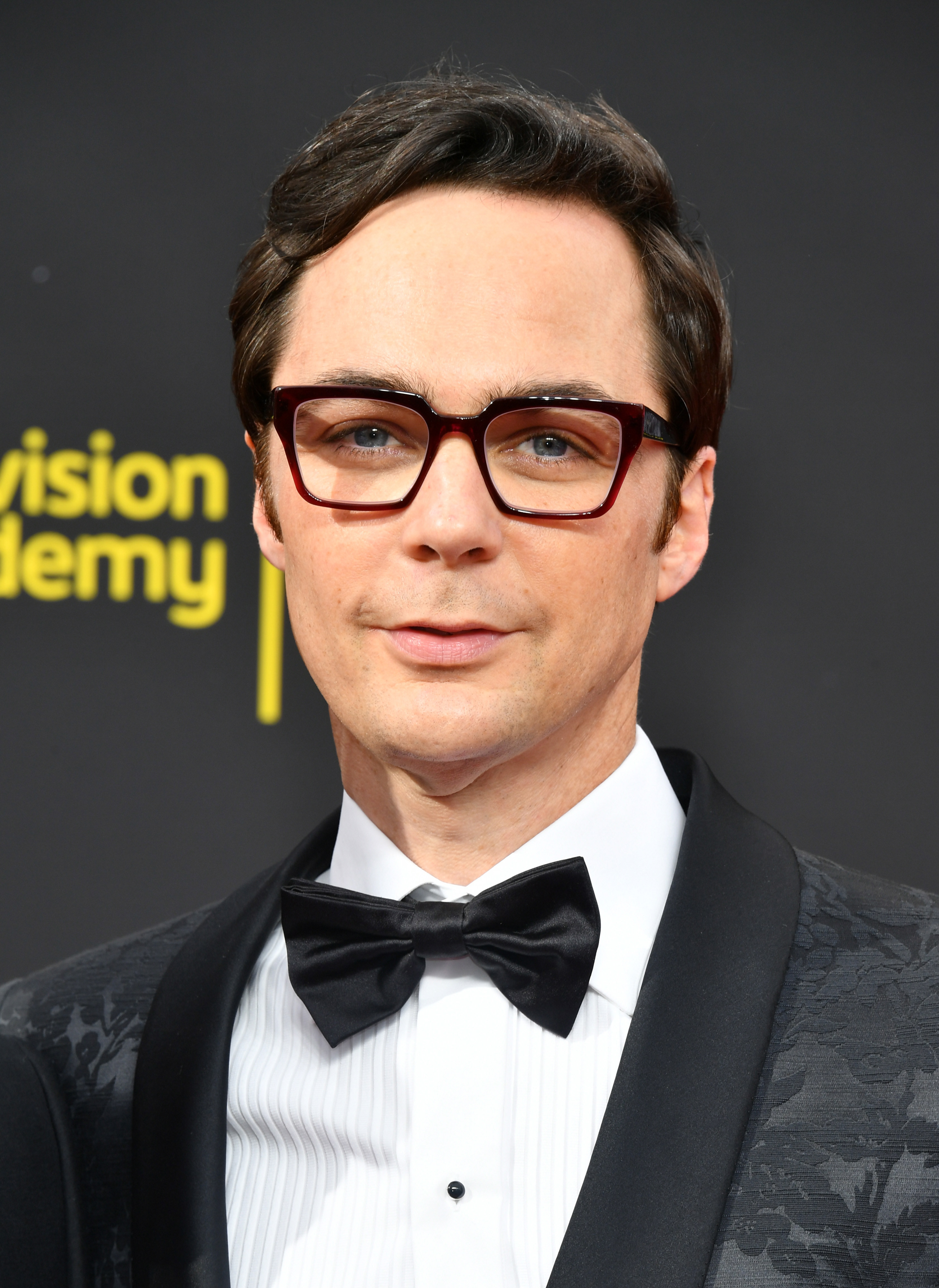 Clean-shaven Jim wearing glasses and in a bow tie and suit