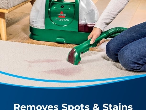 Model using the spot cleaner to remove stain from carpet