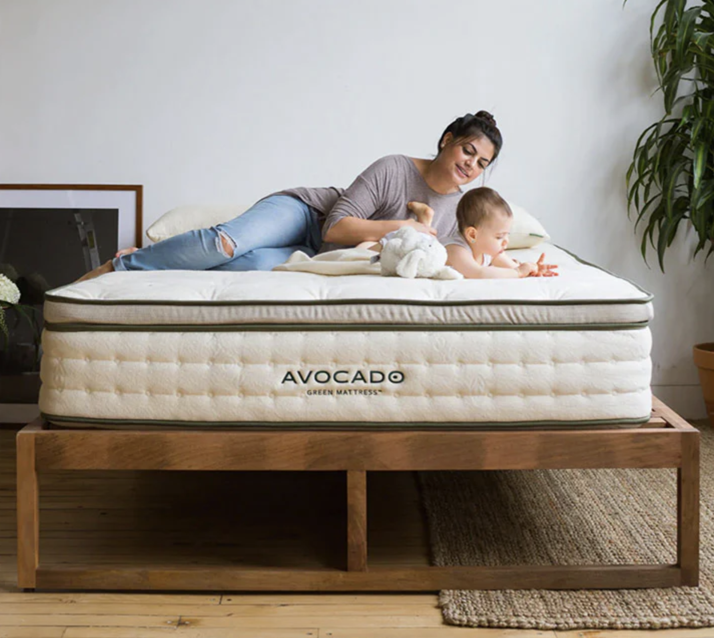 A person and their baby are resting on a mattress