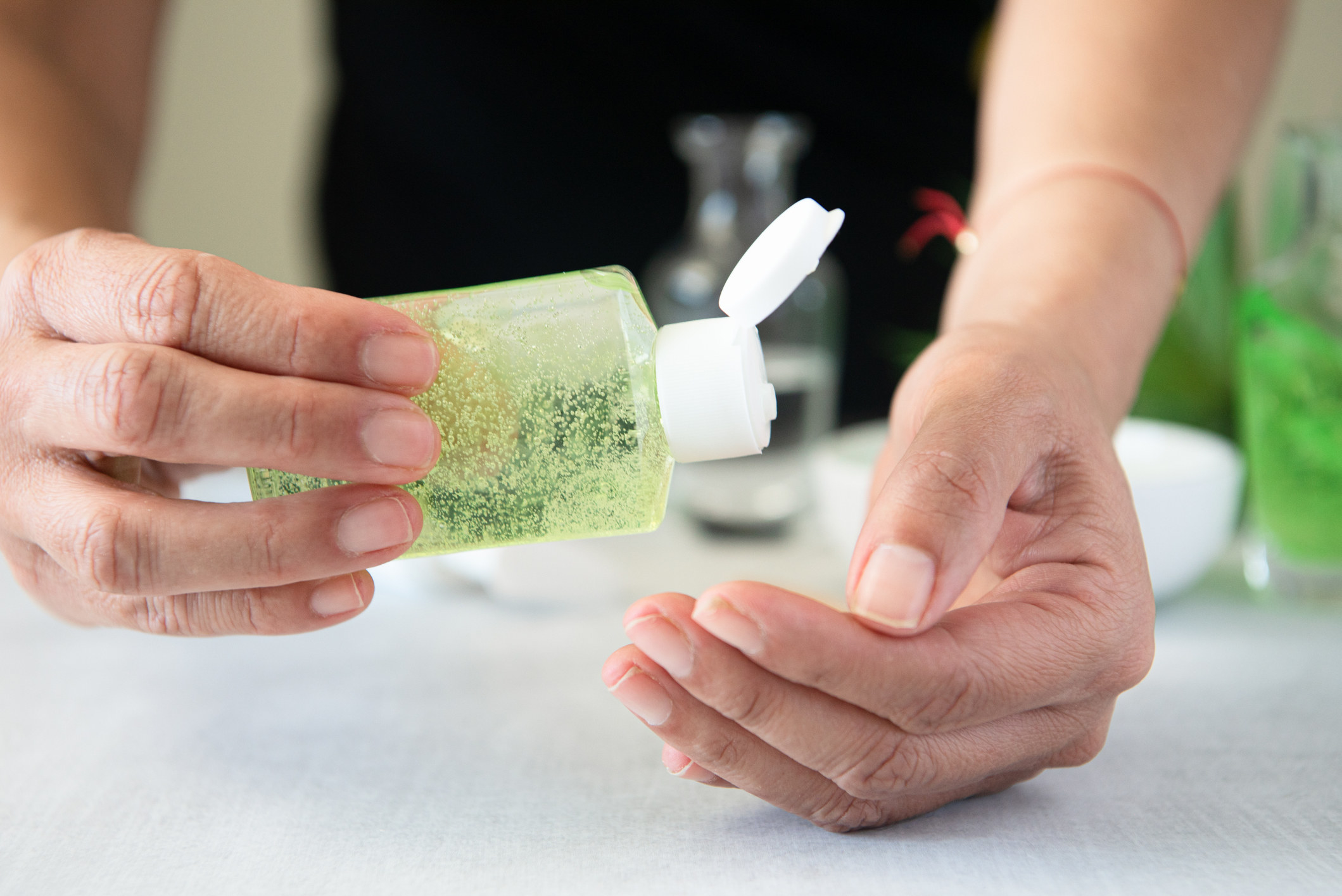 A person pours aloe vera on their hand