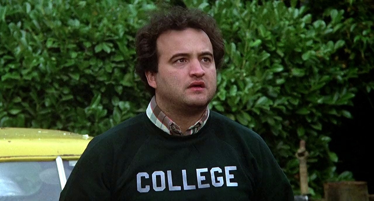 A man wearing a green &quot;college&quot; sweatshirt.
