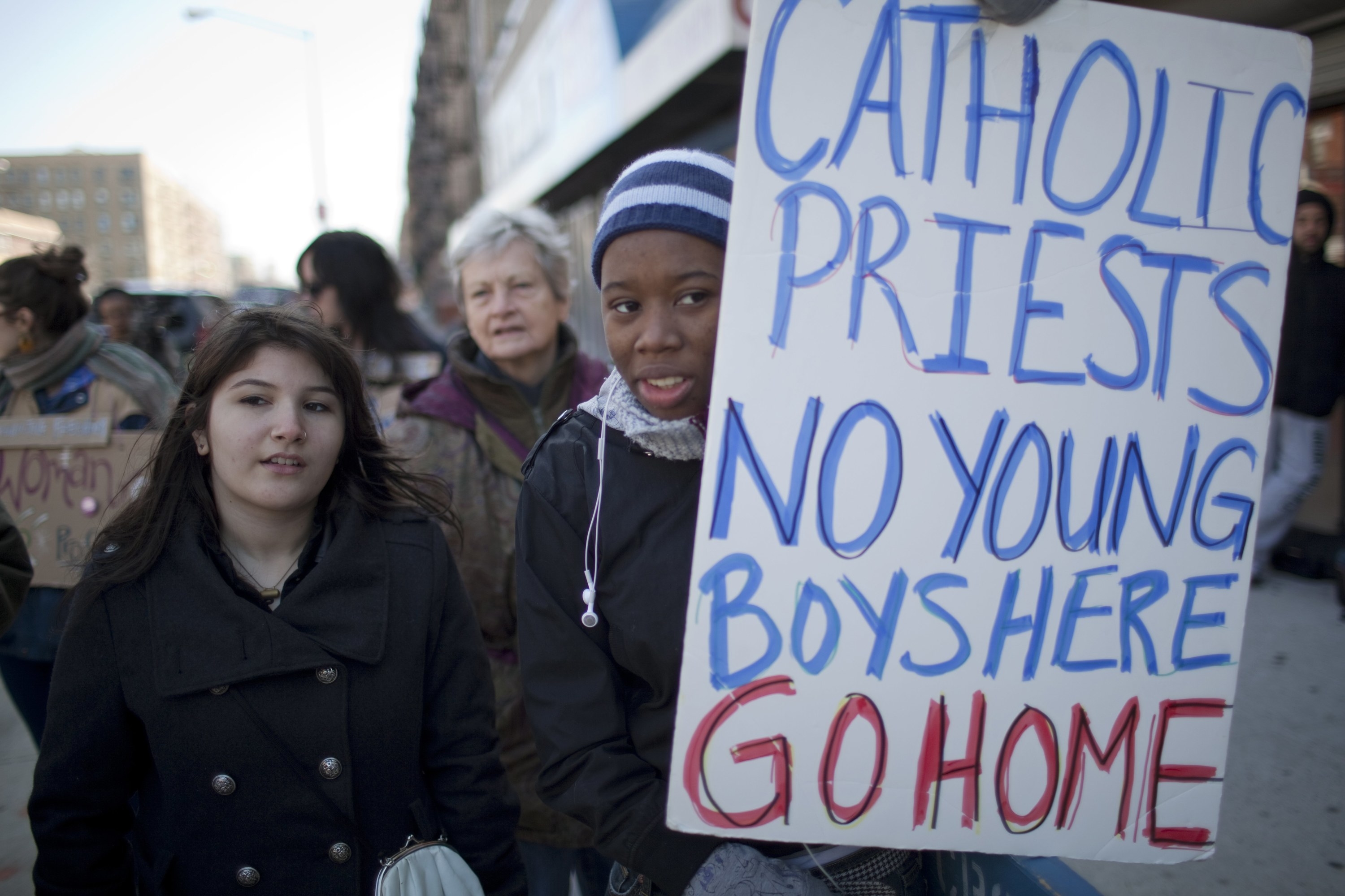 A protester&#x27;s sign reads &quot;Catholic priests no young boys here go home&quot;