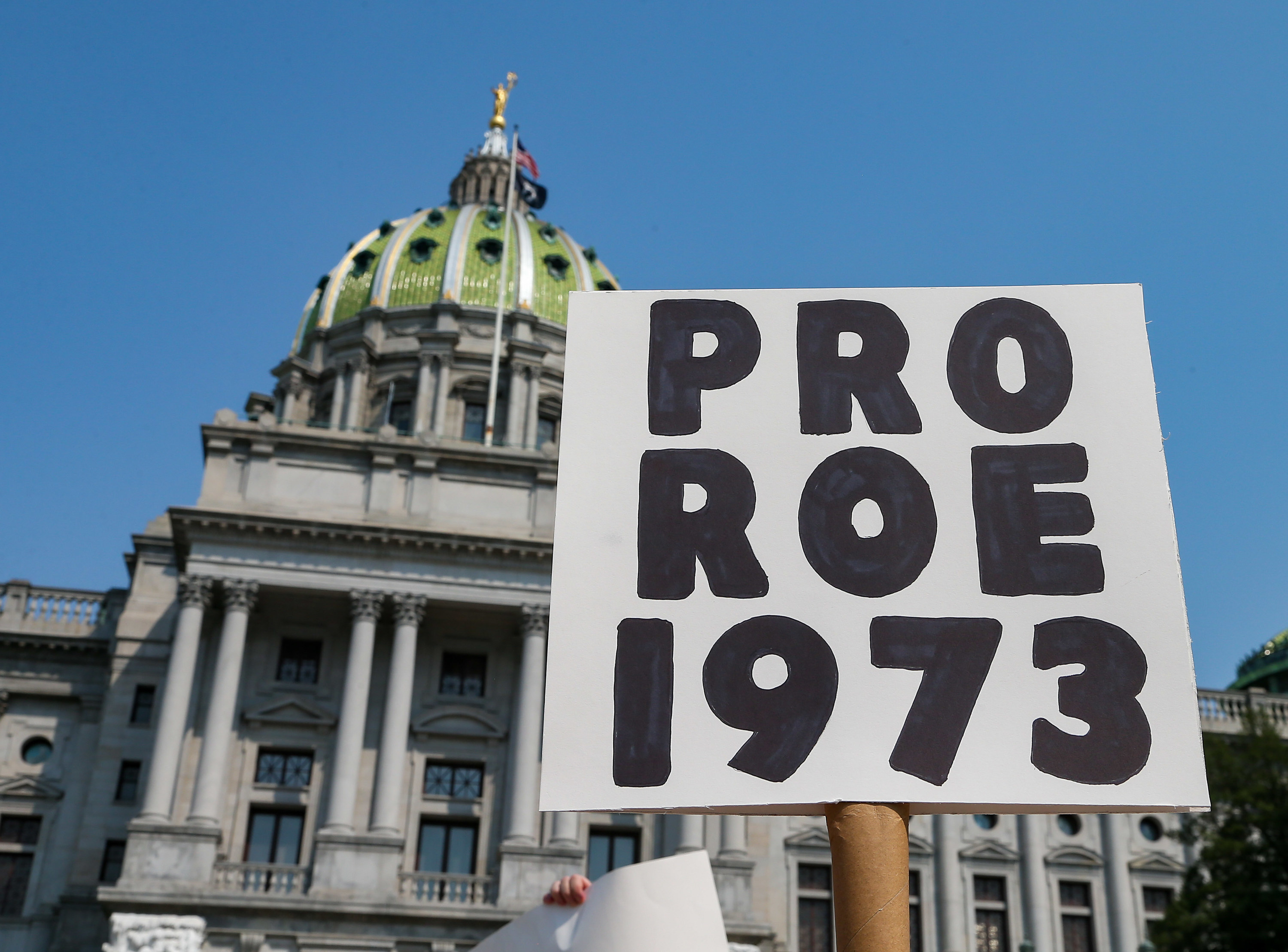 A protest sign in front of a government building reads &quot;pro Roe 1973&quot;