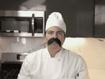 a gif of a person dressed as a chef waving knives around