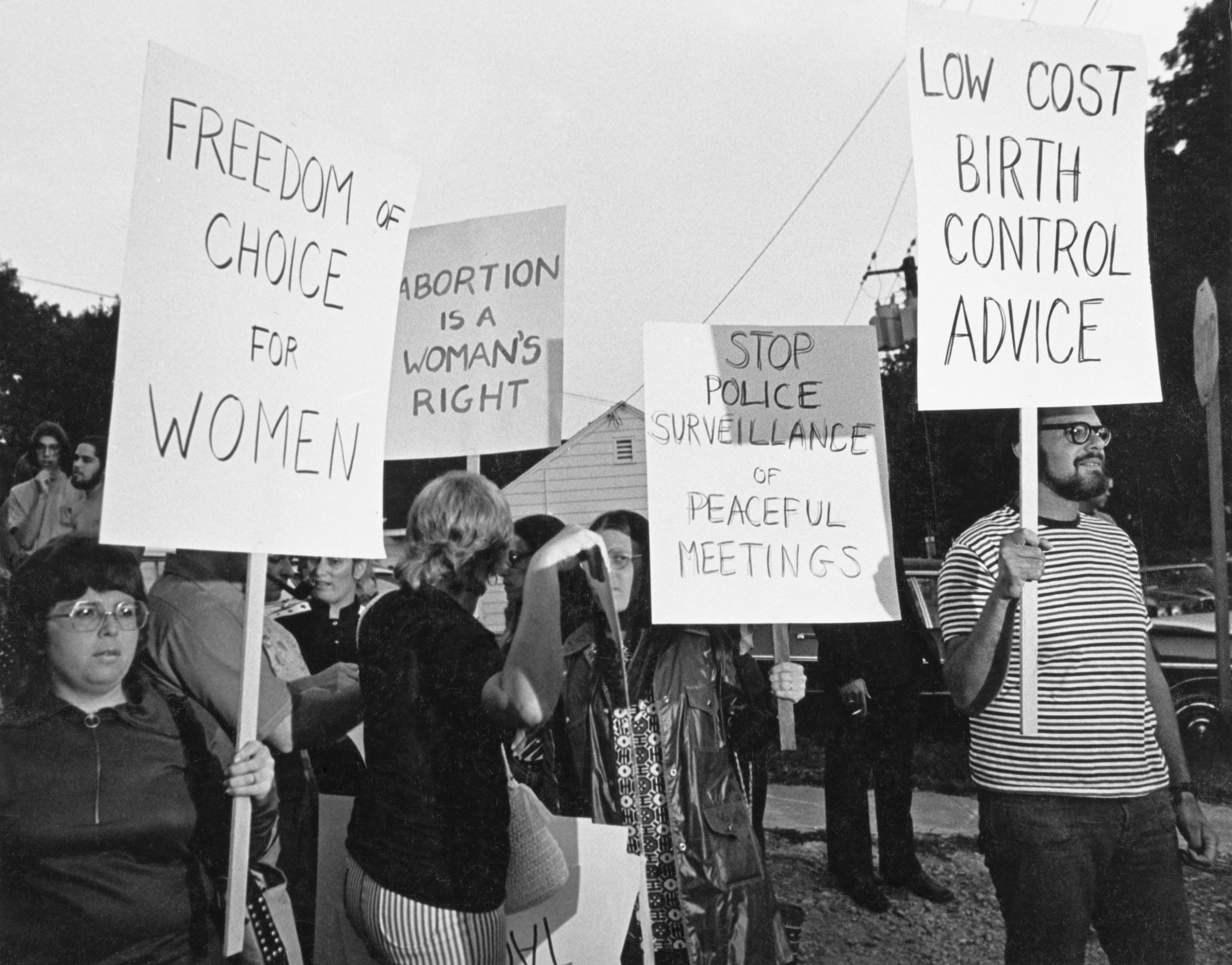 Protesters carry signs reading &quot;freedom of choice for women,&quot; &quot;low-cost birth control advice,&quot; &quot;stop police surveillance of peaceful meetings,&quot; and &quot;abortion is a woman&#x27;s right&quot;