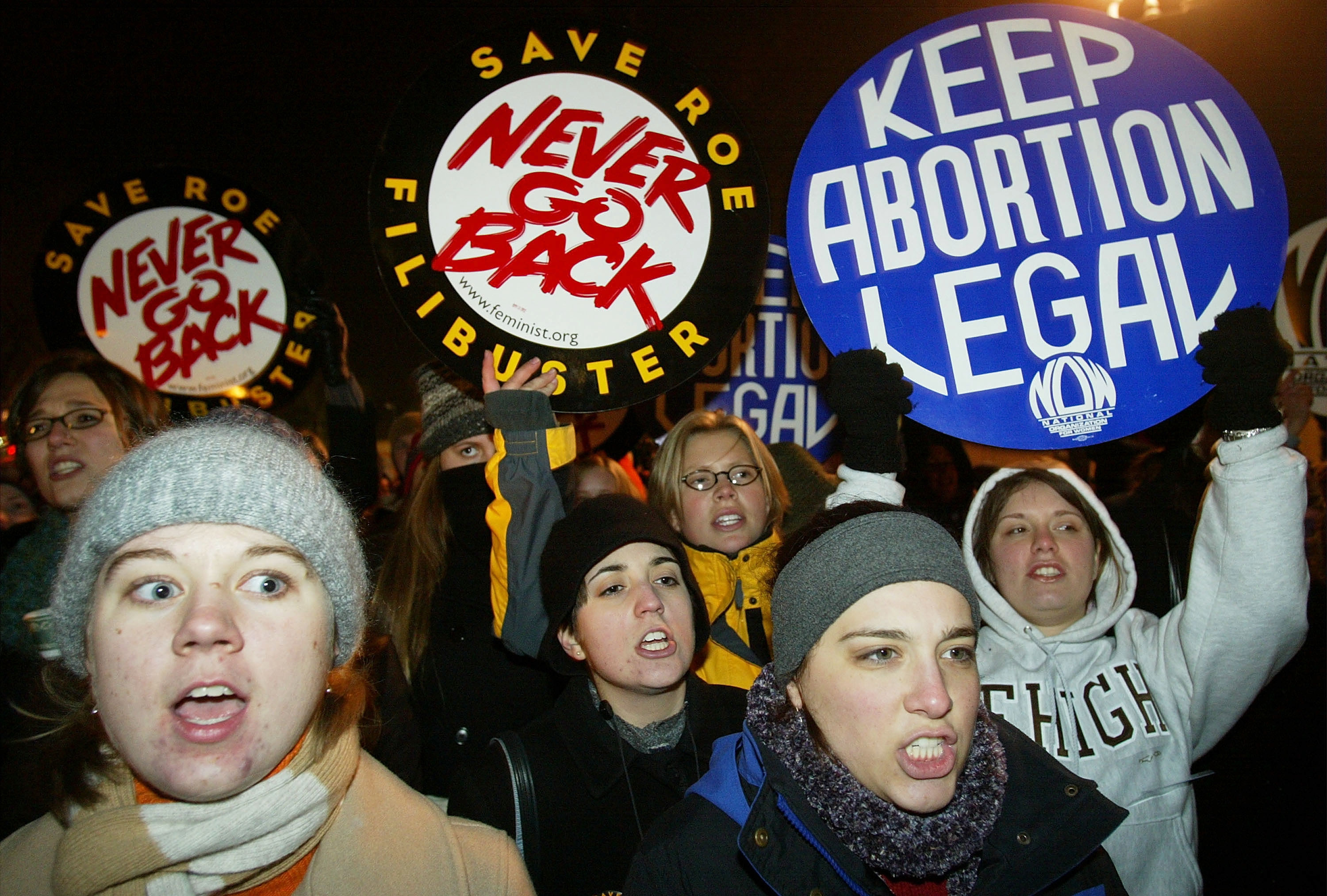 Demonstrators hold up signs reading &quot;never go back&quot; and &quot;keep abortion legal&quot;