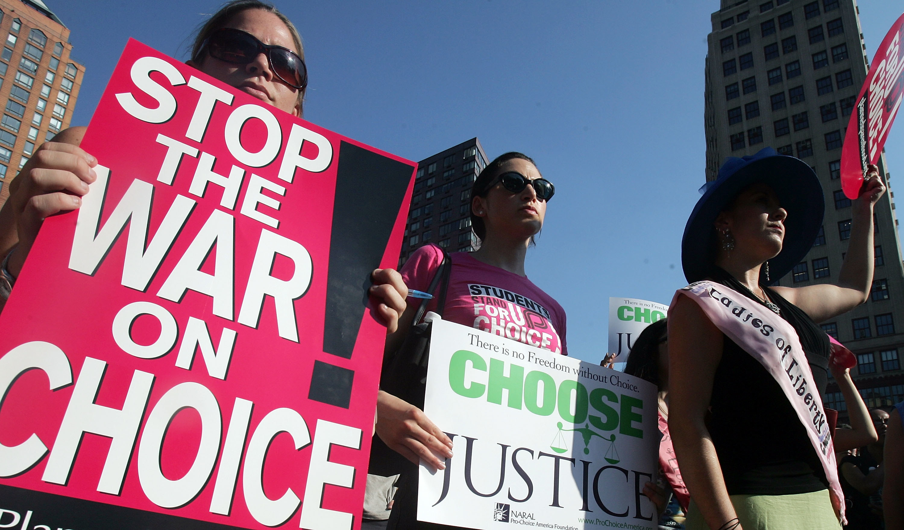 Protesters hold signs reading &quot;stop the war on choice&quot; and &quot;choose justice&quot;