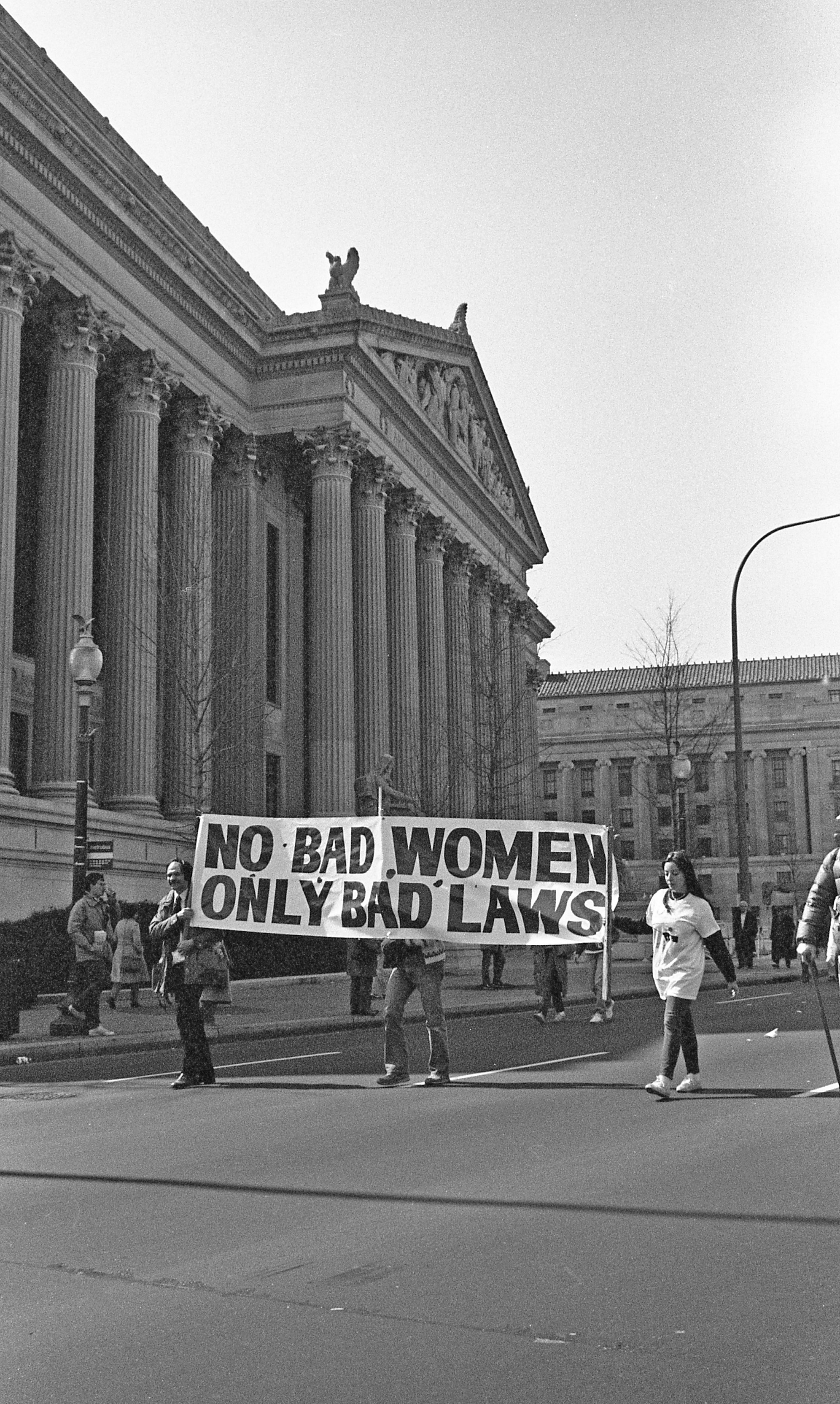 People walking in the street hold up a large banner that reads &quot;no bad women, only bad laws&quot;
