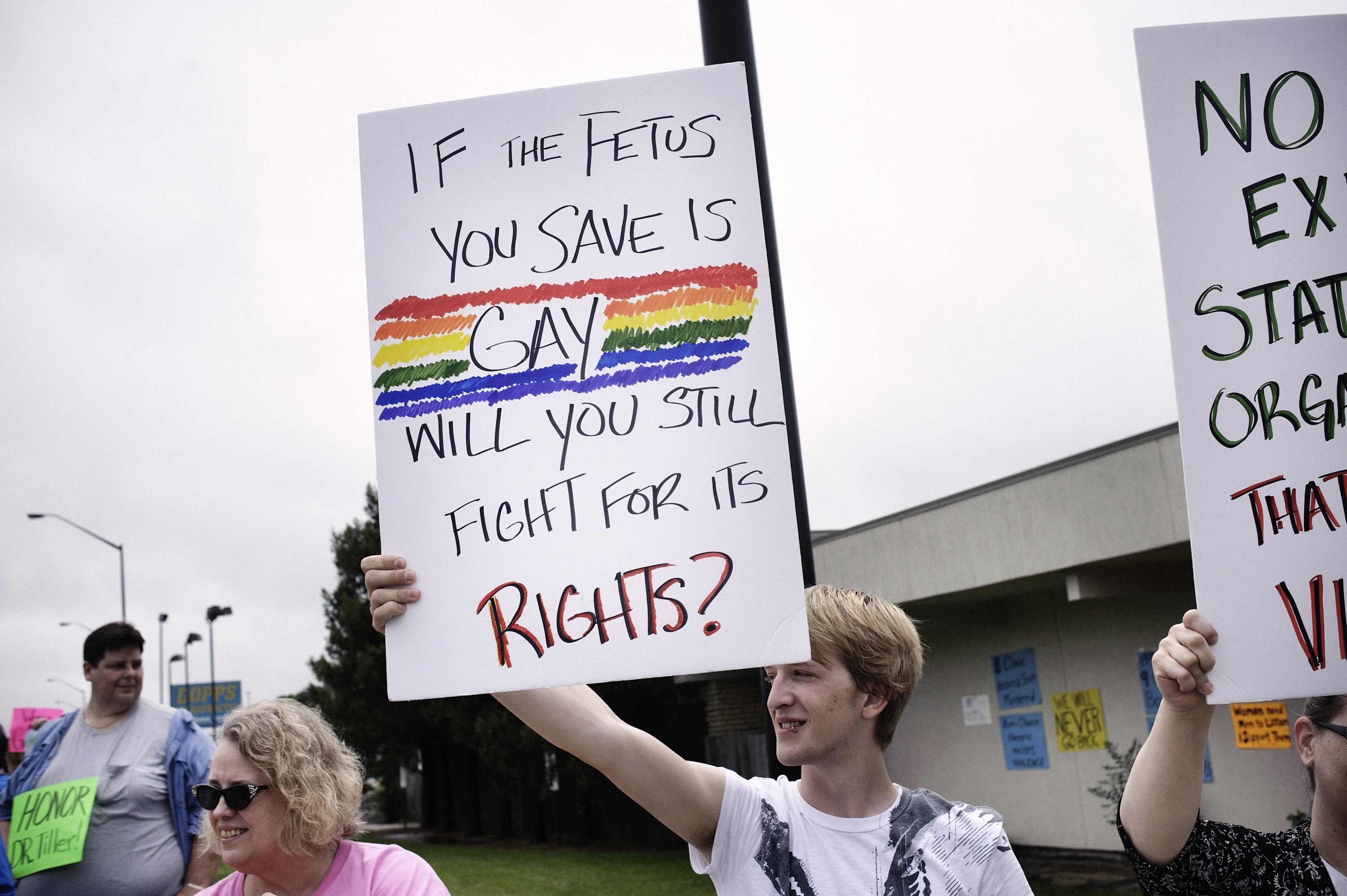 A demonstrator holds a sign reading &quot;If the fetus you save is gay, will you still fight for its rights&quot;