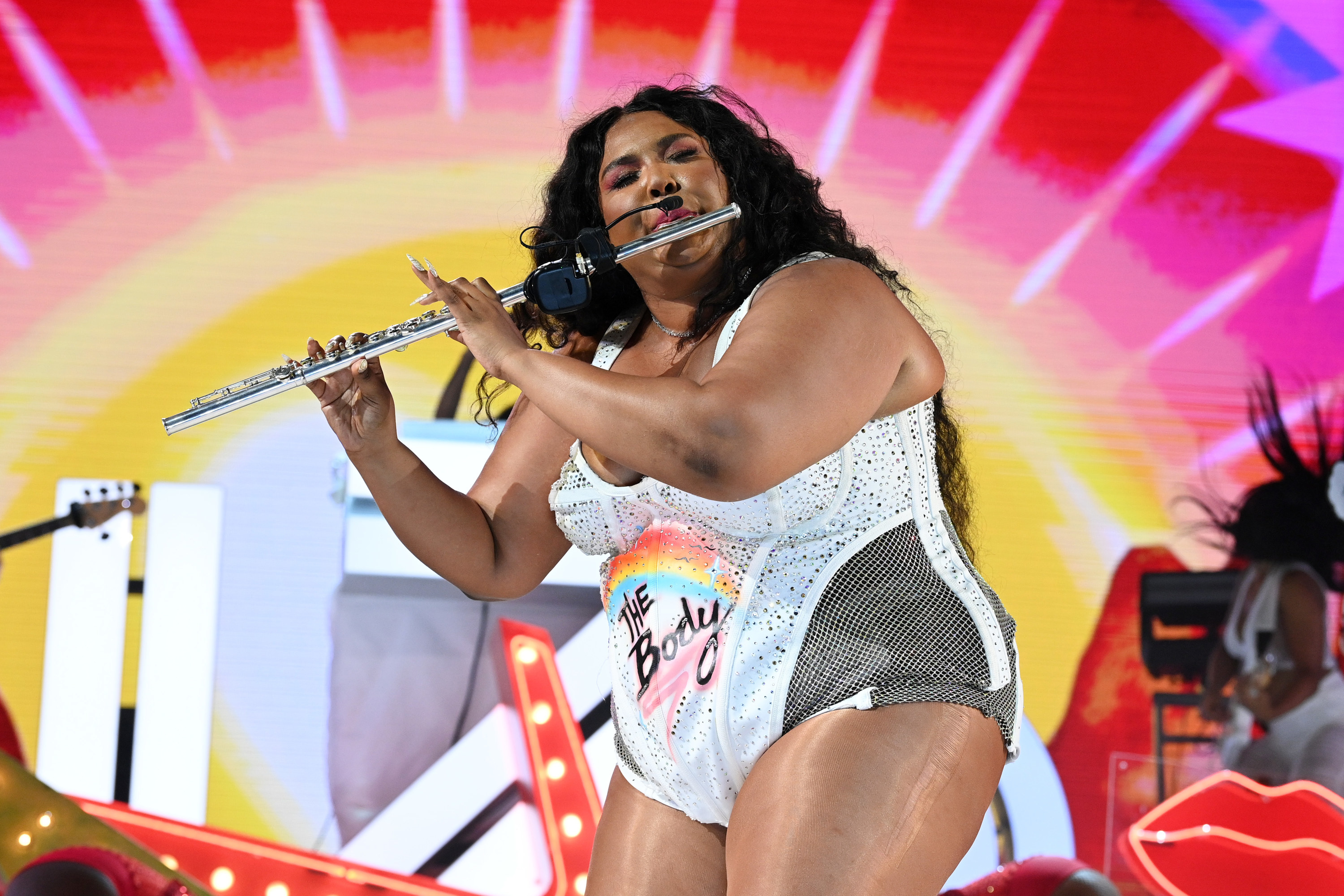 A closeup of Lizzo playing the flute
