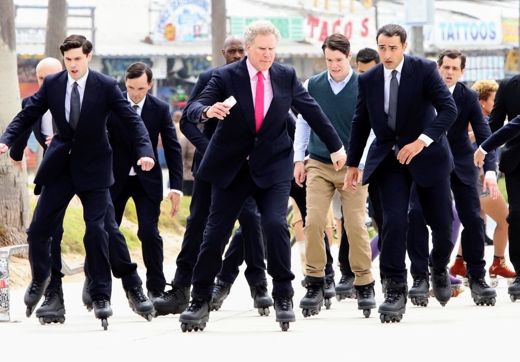 Several men wearing the same suit and looking either angry or upset while rollerblading