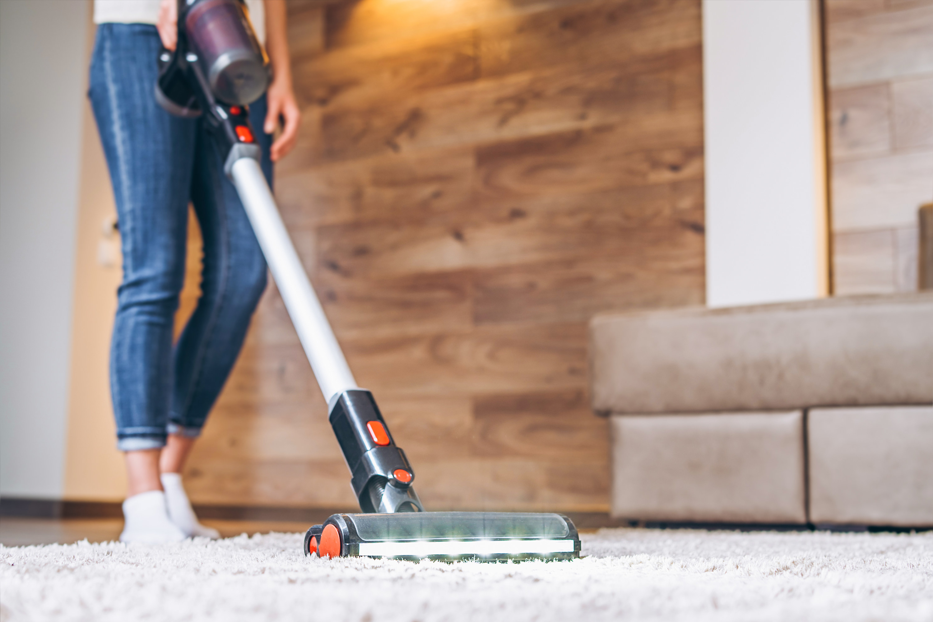 A woman vacuums her carpet.
