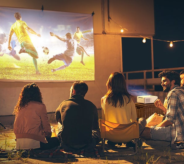four people watching soccer from a projector