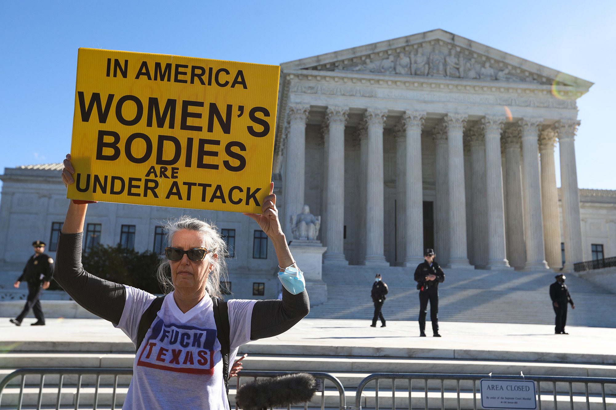 A demonstrator wearing a shirt that says &quot;fuck Texas&quot; holds up a sign reading &quot;in America women&#x27;s bodies are under attack&quot;