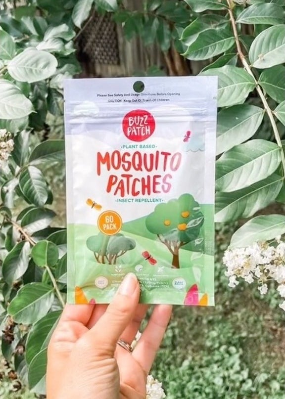 a person holding up a pack of the mosquito-repelling stickers