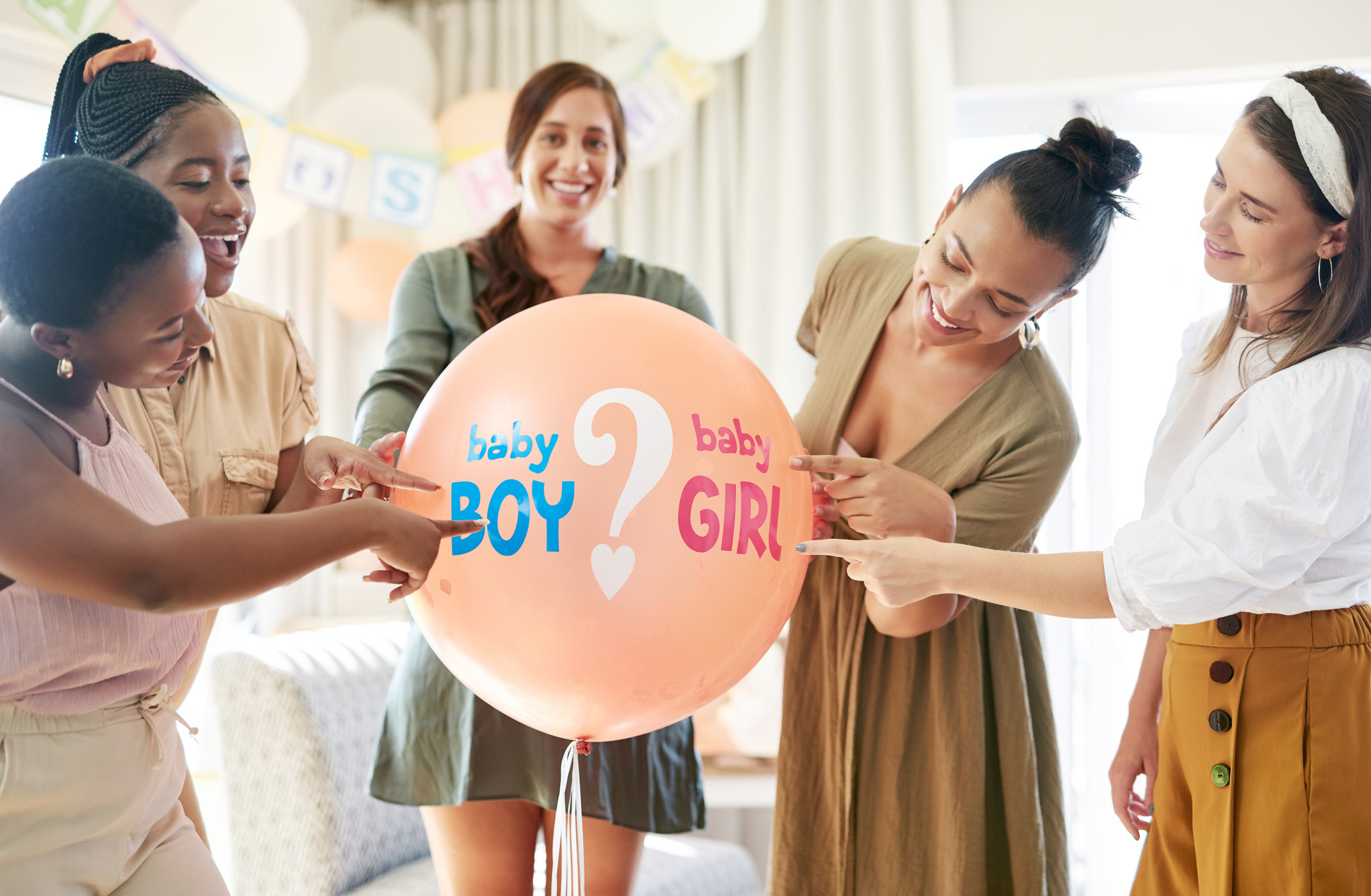 A group holds a balloon that says, Baby boy? Baby girl?