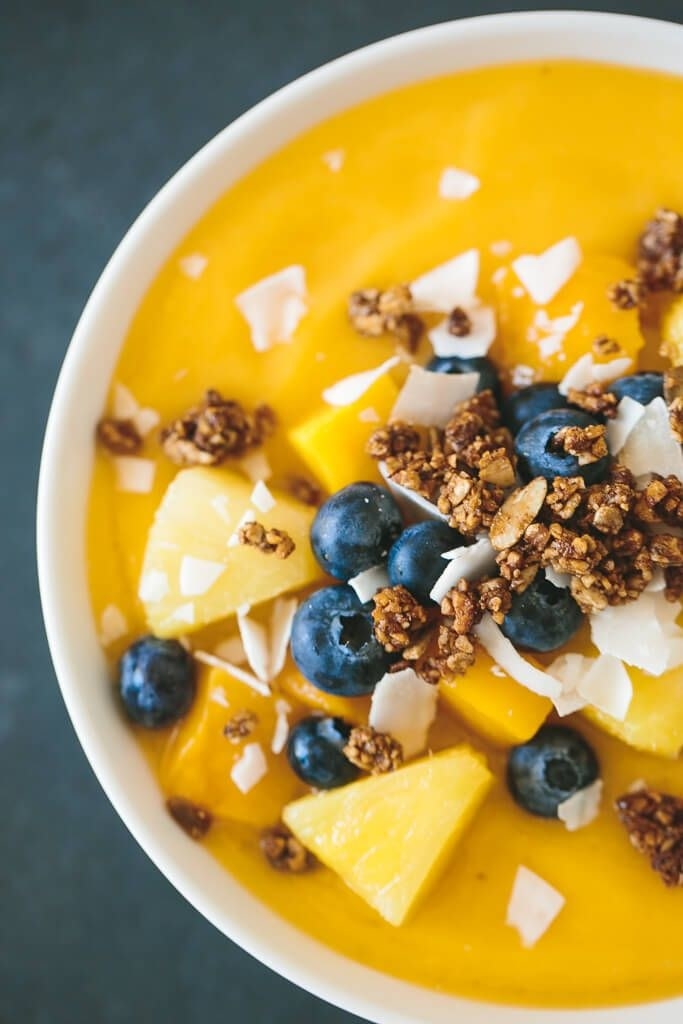 A mango smoothie bowl with granola and more fruit.