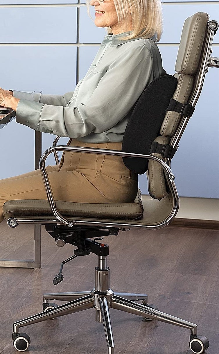 a person sitting at their desk with the cushion on their chair