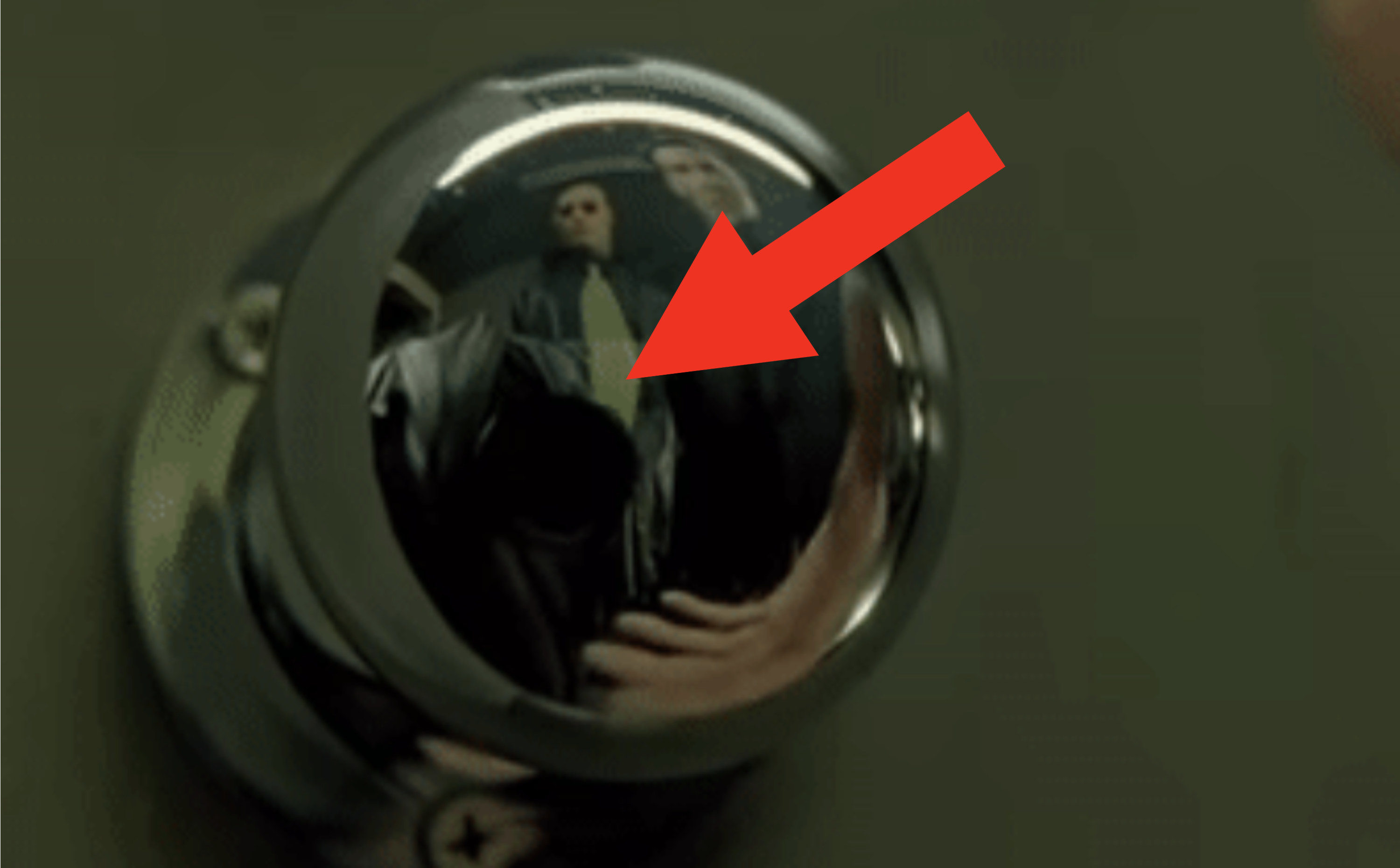 Closeup of the doorknob with a cameraman in the reflection