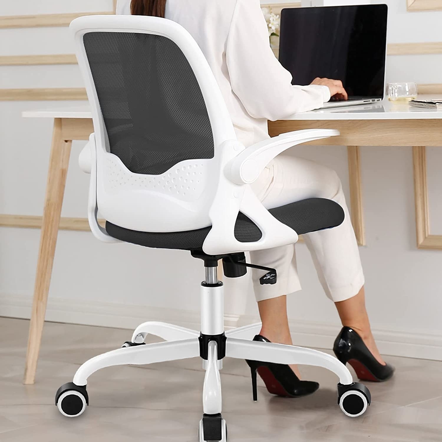 a person sitting on the office chair while working at a desk