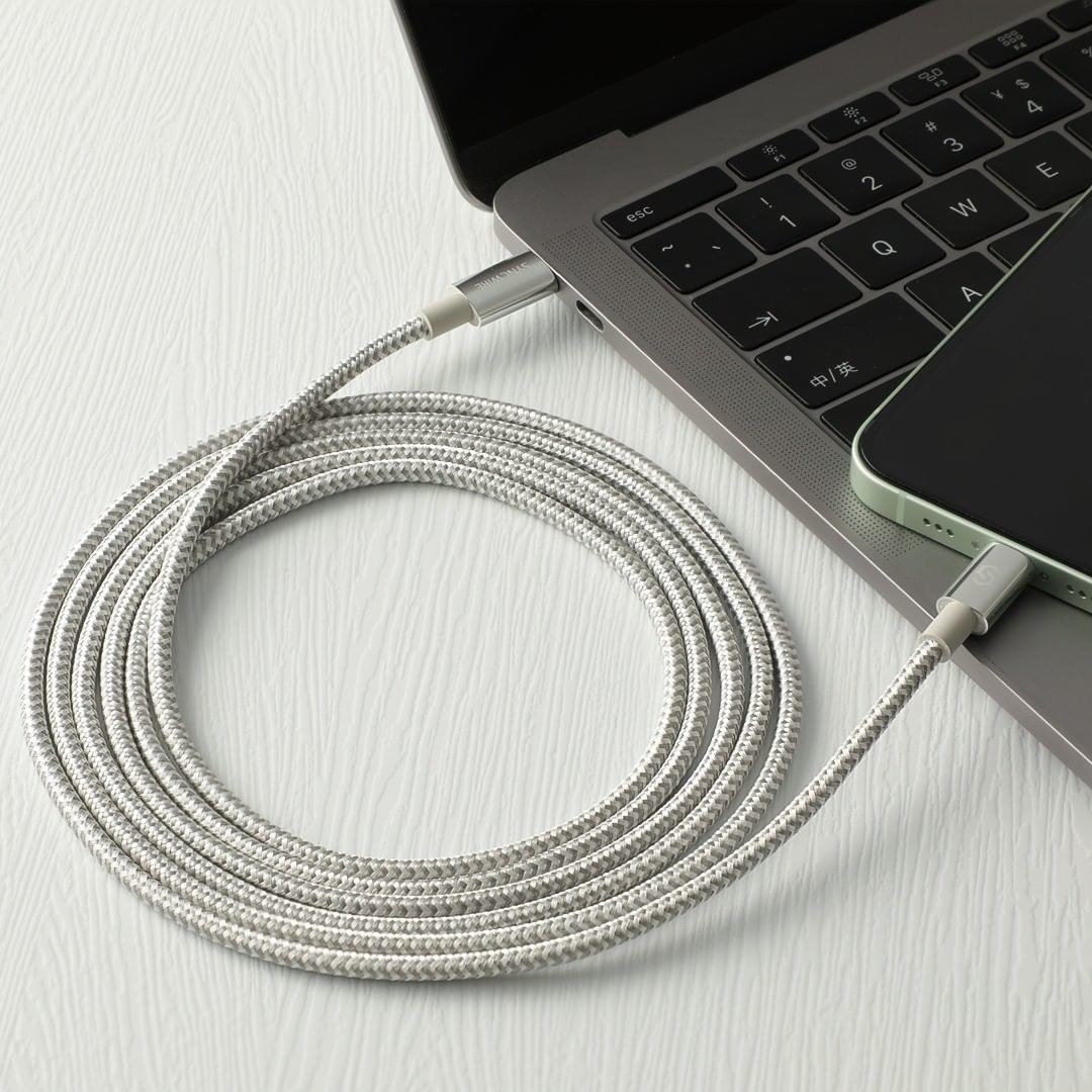 the long charging cable coiled and plugged into a phone and laptop at either end
