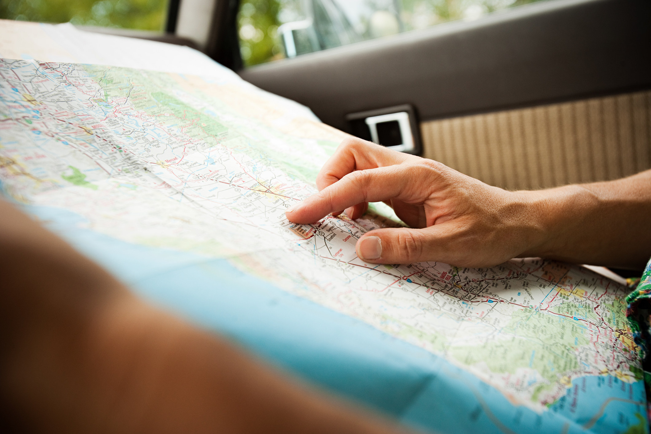 Person with a map in a car