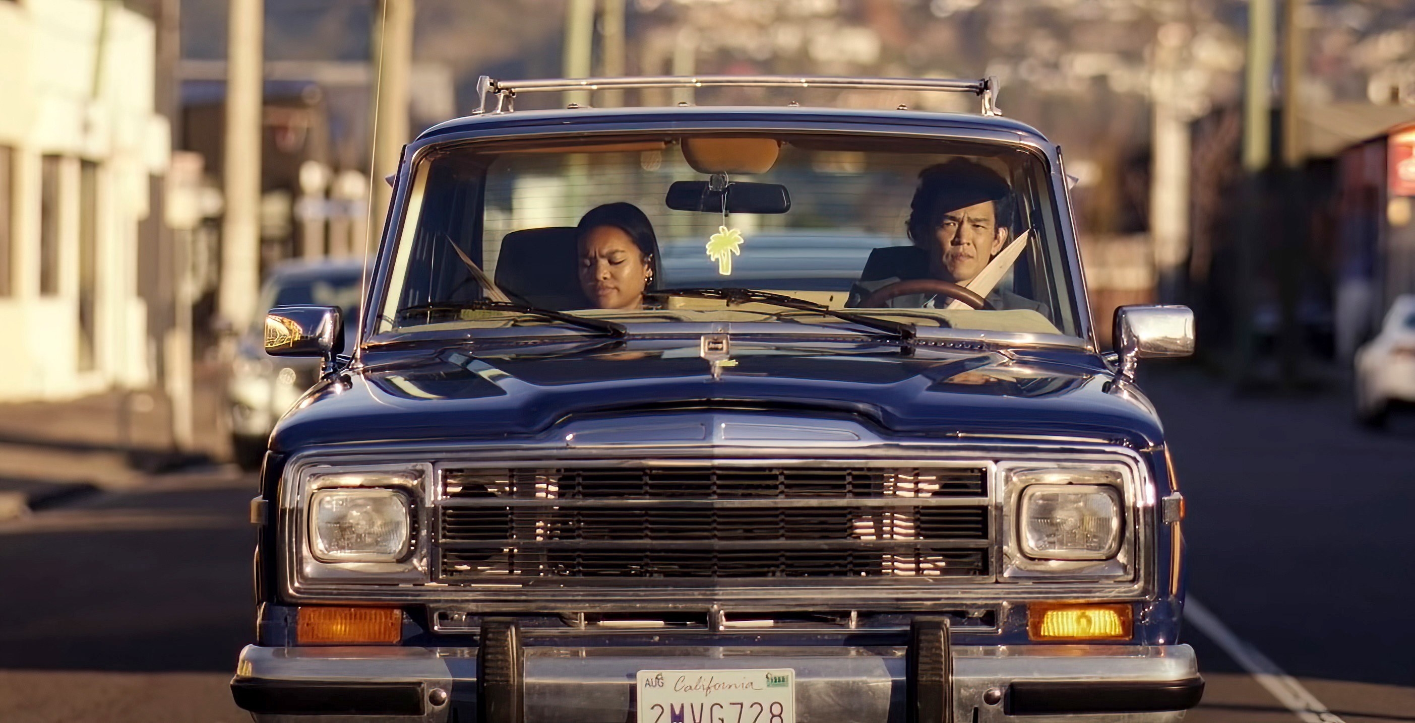 Mia Isaac and John Cho ride in a car together