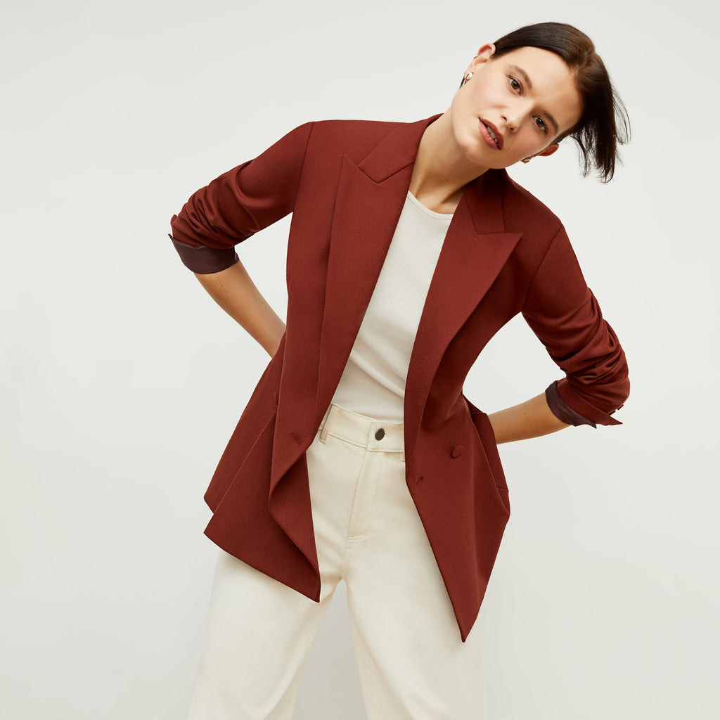 a model wearing the blazer in a orangish brown color