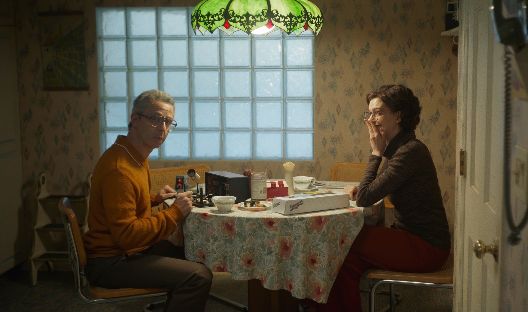 Jeremy Strong and Anne Hathaway sit at a table together