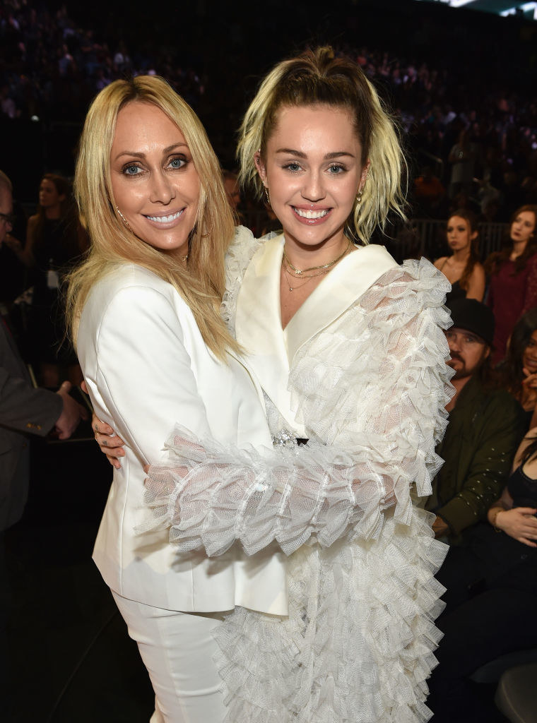 Miley Cyrus and her mom smiling with their arms around each other