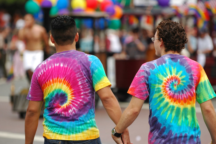 people holding hands wearing tie dye shirts