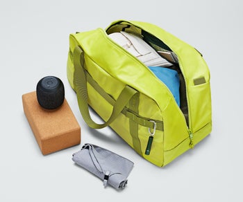 chartreuse-colored duffle bag open to show the contents inside it