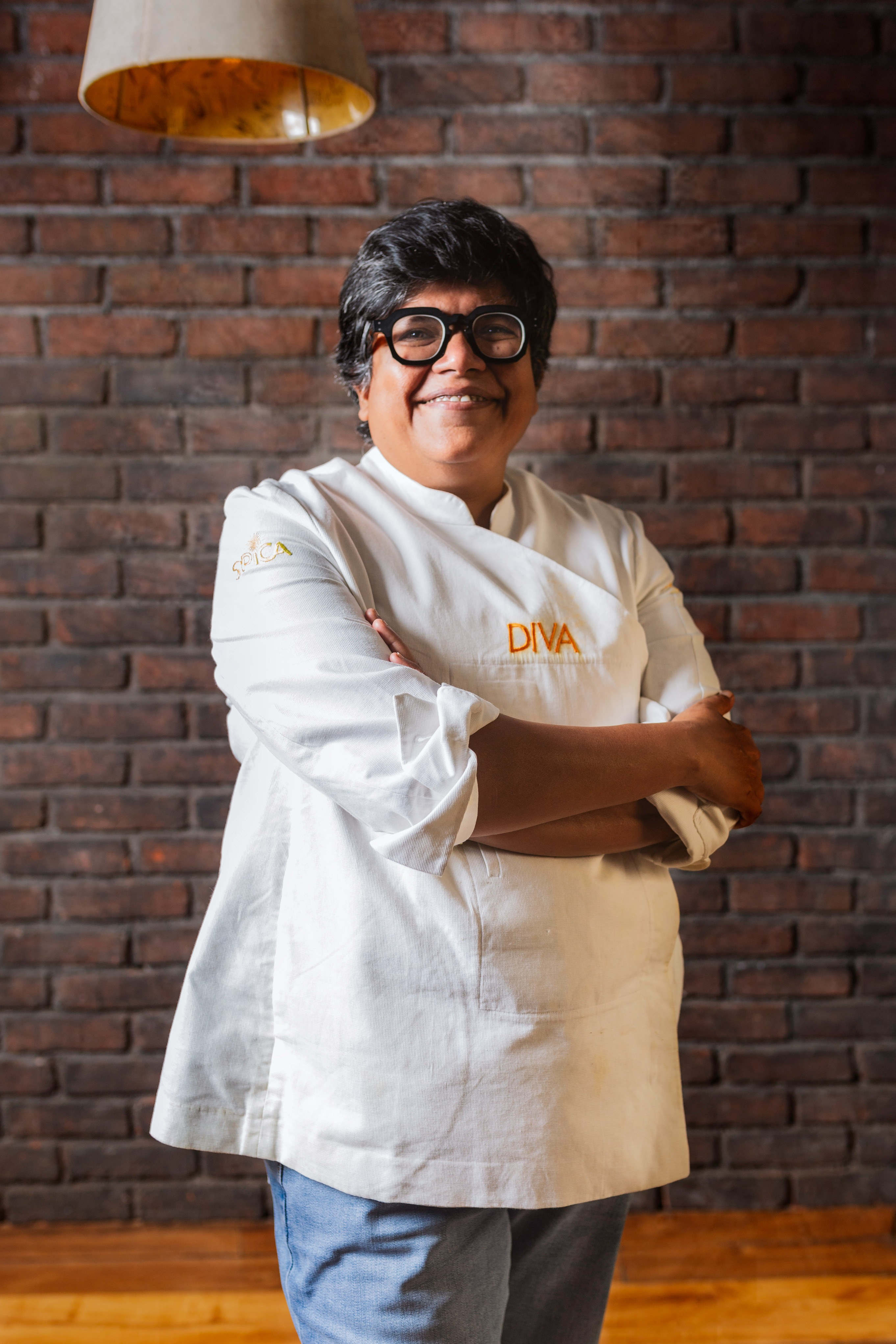 Chef Ritu standing in front of a wall with arms crossed