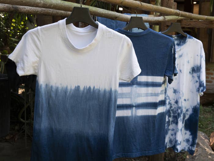 Three tie dyed short sleeve shirts hang on a clothing line