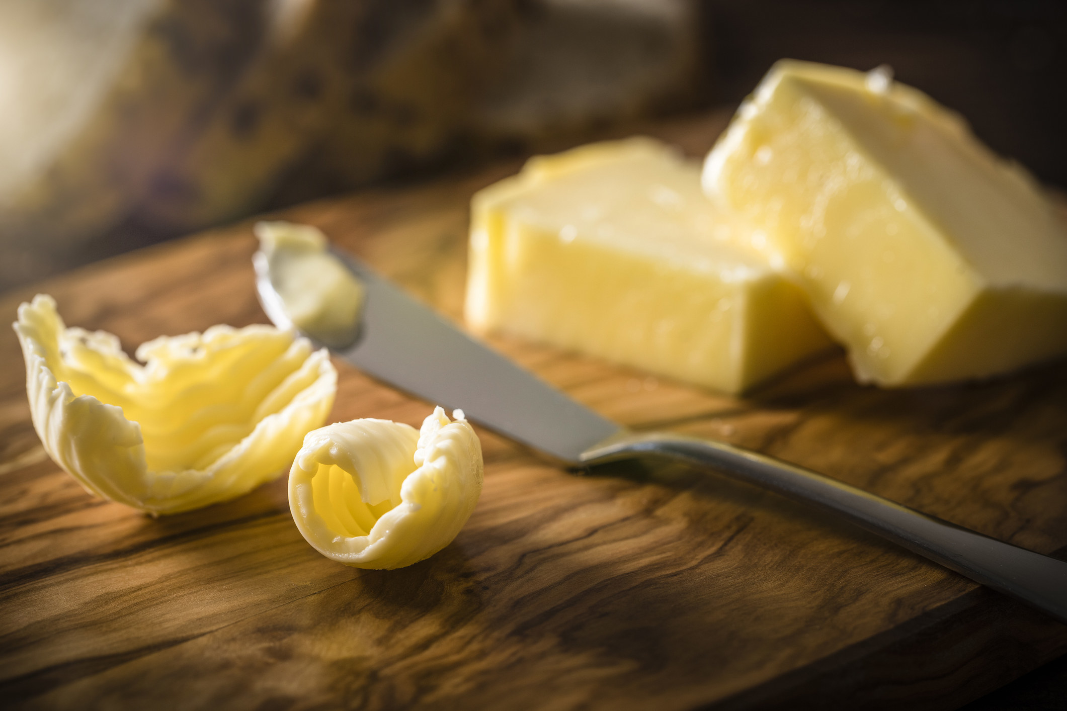 Pats of margarine and butter on a cutting board