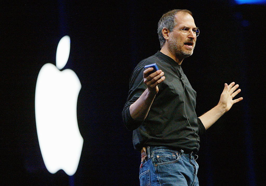 Steve Jobs onstage in front of the Apple logo