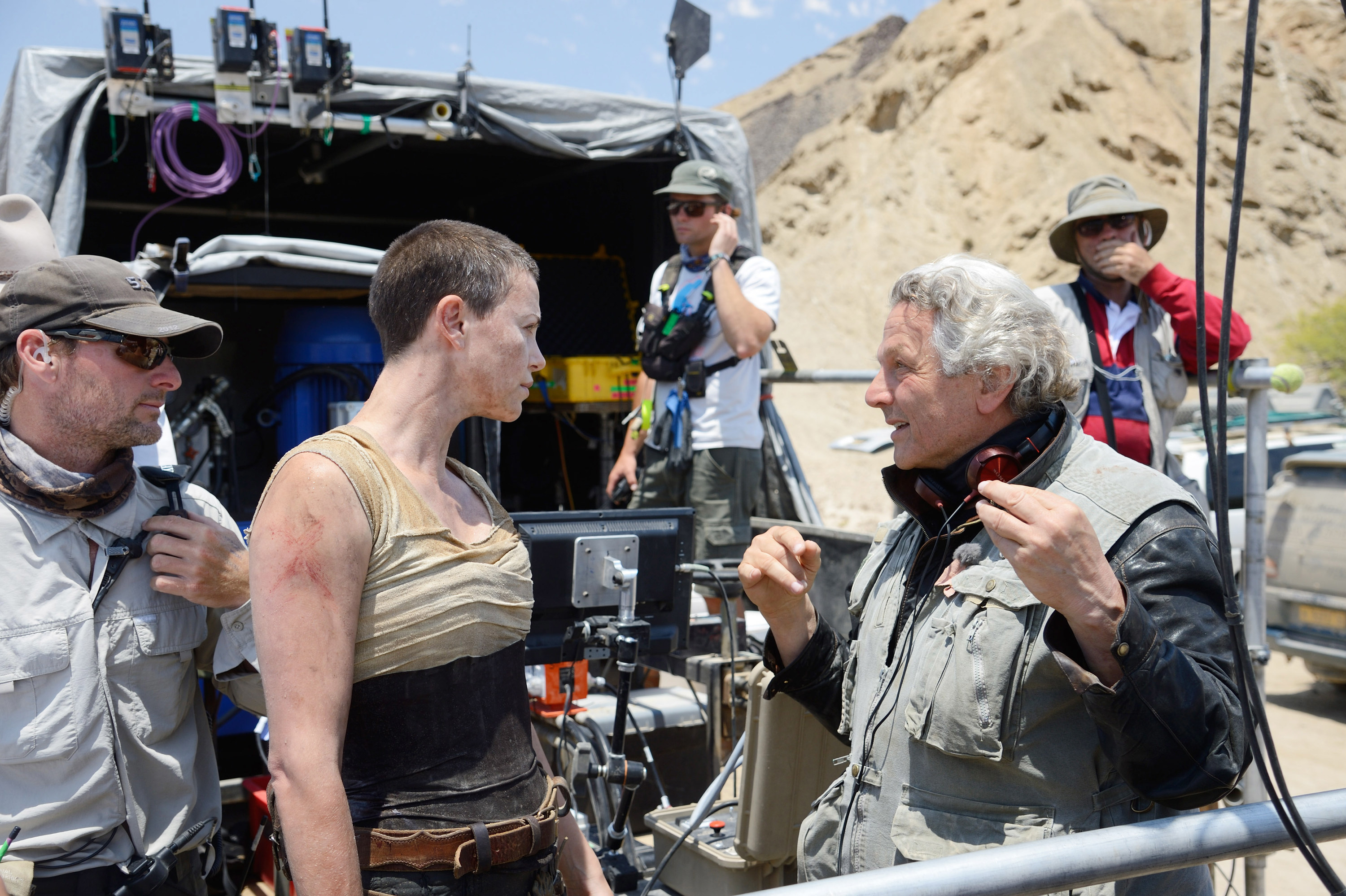 Charlize Theron chatting with director George Miller on set
