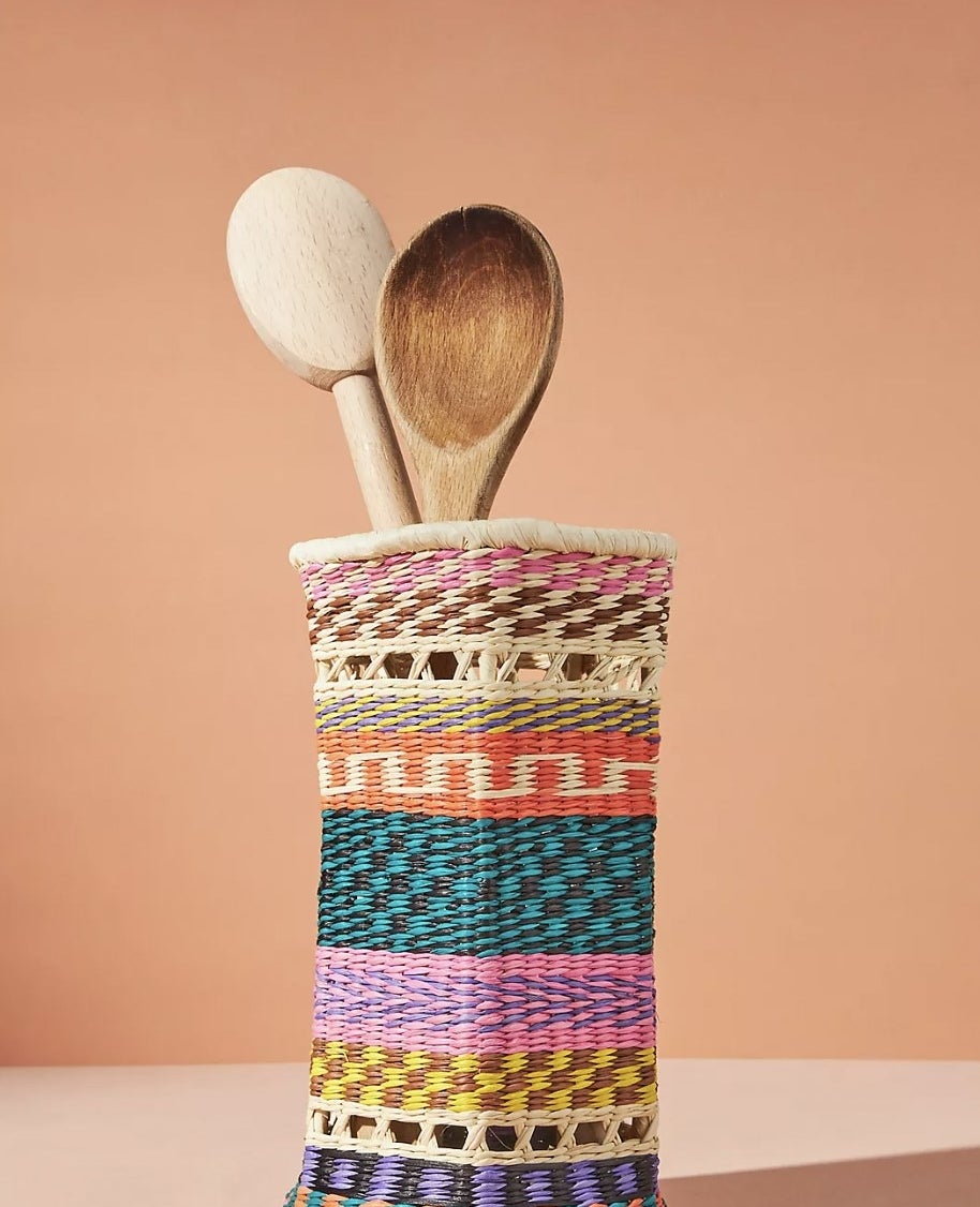 The tall vertical utensil jar with two wooden spoons sticking out top