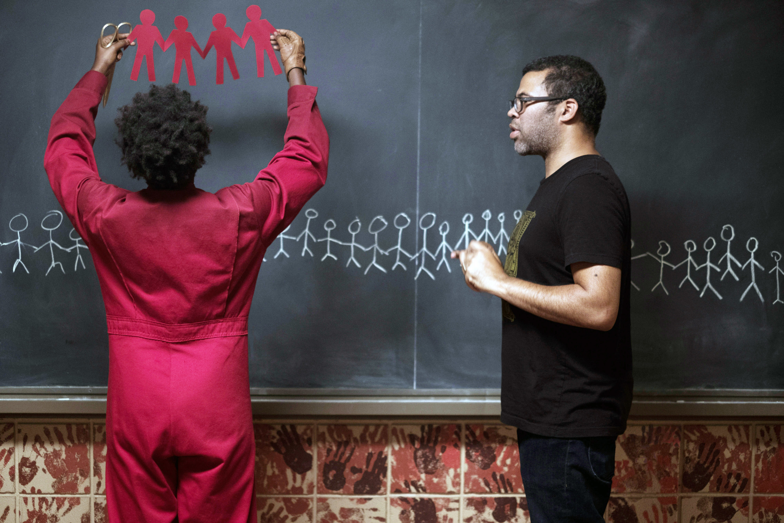 Lupita Nyong&#x27;o and Jordan Peele standing in front of a chalkboard