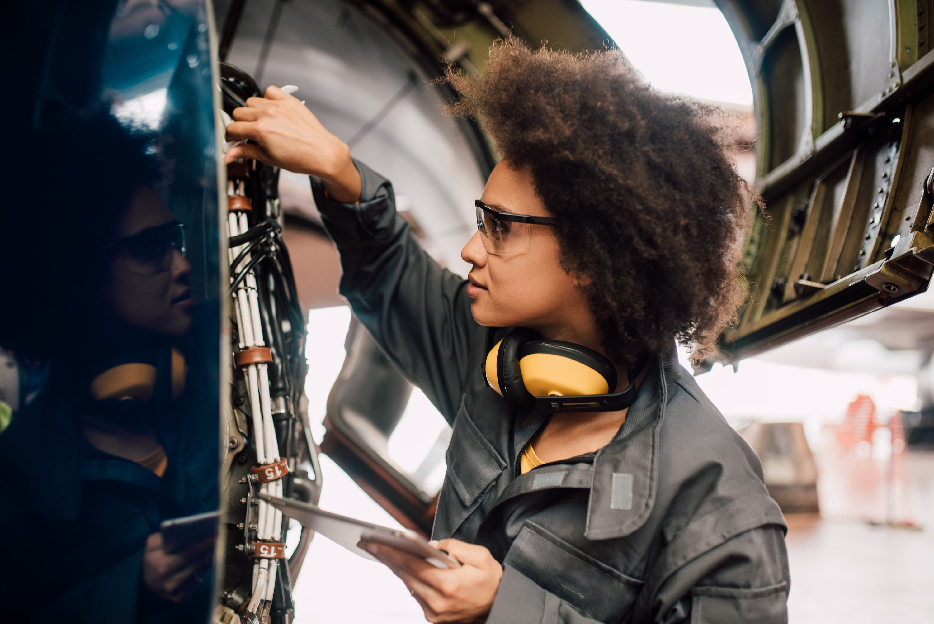 A female engineer checks on the parts of an aircraft
