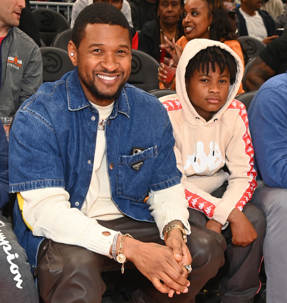 Usher and Usher jr sitting to watch a game