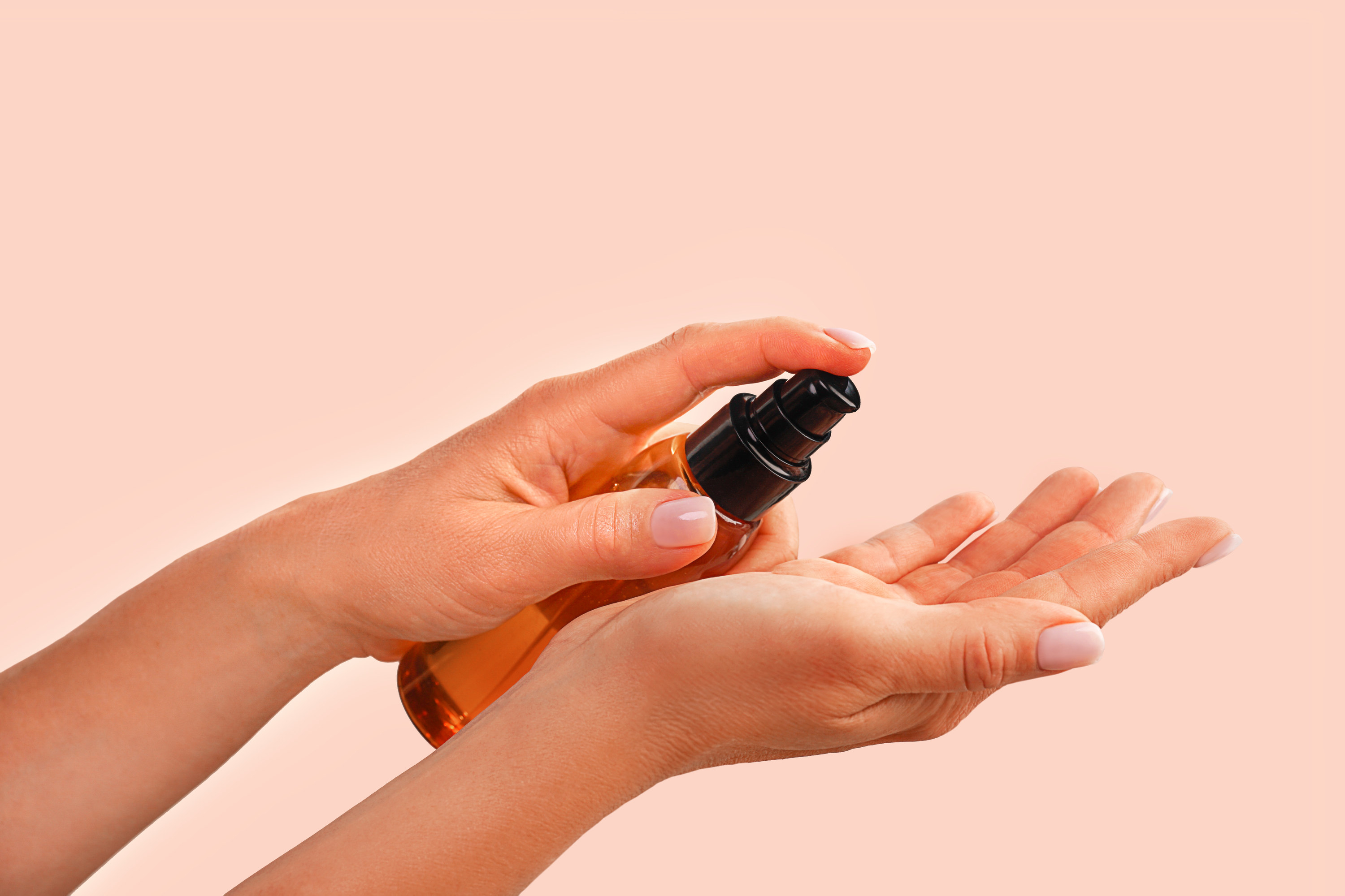 a person spritzing product on their hand