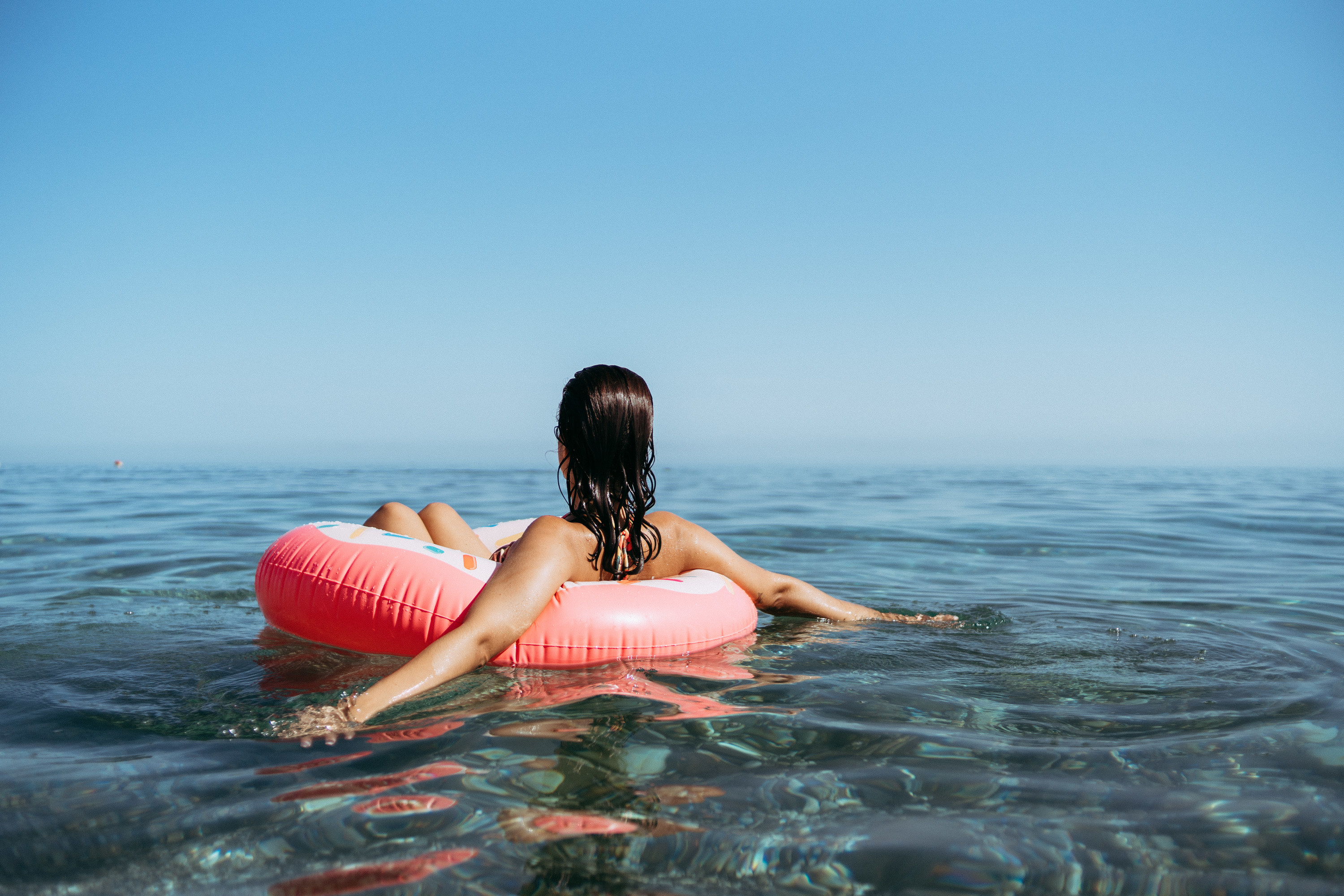 a person sitting on a floating device in the ocean
